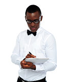 Confident young man writing on notepad