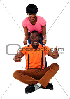 Couple showing double thumbs-up to camera