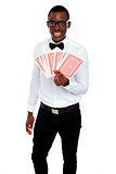 A man holding up a few playing cards