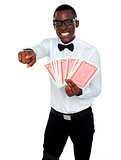 Gambler with playing cards pointing at you