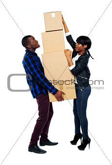 A young couple holds boxes in studio