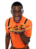Boy in uniform offering pizza