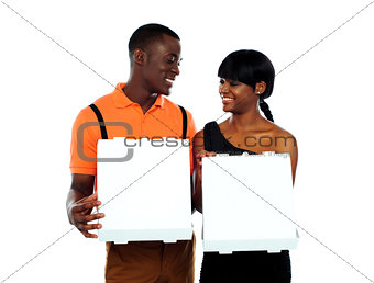 Loving couple holding pizza boxes