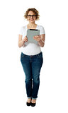 Full length of pretty woman holding tablet pc
