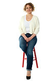 Confident smiling woman sitting on stool
