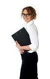 Smiling corporate woman posing with clipboard