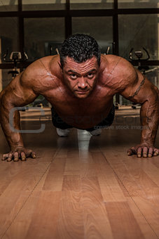 male bodybuilder doing push ups at the floor