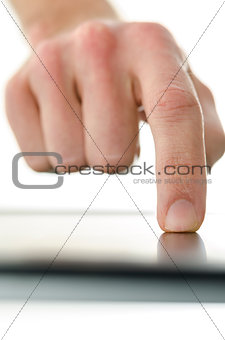 Detail of male hand working on touch screen device