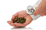 Male hand holding stethoscope on  hand holding coffee grains