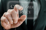 Business man pointing at Customer service icon on a virtual scre