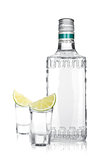 Bottle of silver tequila and two shots with lime slice