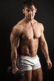 Muscular young man with a dumbbell