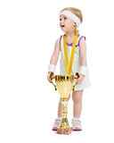 Happy baby in tennis clothes with medal and goblet looking on co