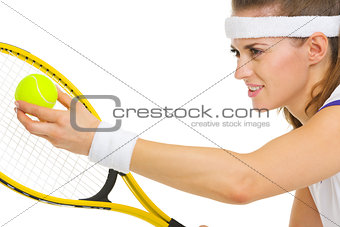 Closeup on female tennis player serving ball