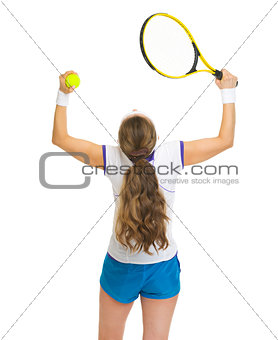 Happy female tennis player rejoicing success. rear view
