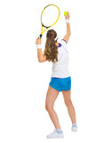 Female tennis player serving ball. rear view