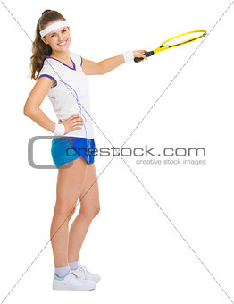 Female tennis player pointing on copy space with racket