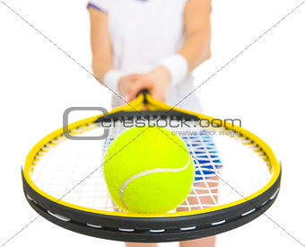 Closeup on tennis ball on racket in hand of female tennis player