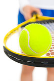Closeup on tennis ball on racket in hand of tennis player