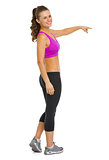 Full length portrait of happy fitness young woman pointing on co