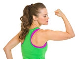 Fitness young woman showing biceps
