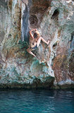 Young female rock climber on face of cliff