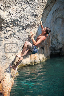 Deep water soloing, rock climber on cliff