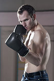 Waist-up of male boxer in gym