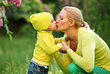 Little boy kissing his mother outdoors