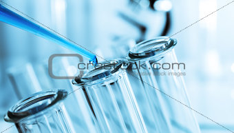 pipette and test tube on blue background.
