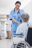 Doctor greeting recovering senior patient in wheelchair