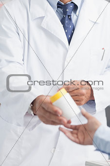 Pharmacist giving a box of pills to someone