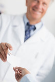 Customer handing a Rx prescription to a pharmacist