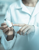 Vial being pointing at by a person in a laboratory coat