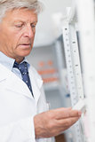 Pharmacist looking at pills in a shelf