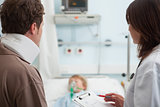 Doctor and a patient looking at a child patient in a hospital