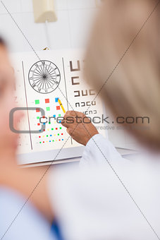 Eye test board being pointed at by a doctor in a hospital