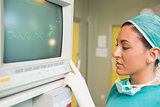 Smiling female surgeon standing next to a monitor