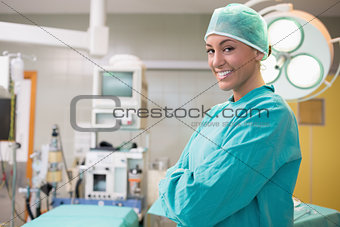 Happy surgeon crossing her arms in an operation room