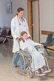Doctor wheeling a patient in a wheelchair