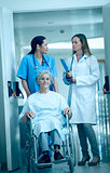 Nurse wheeling a senior patient patient in a hallway