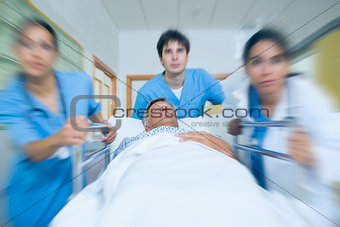 Team of doctor running in a hospital hallway