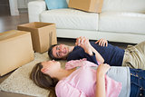 Couple lying on the floor with their moving boxes