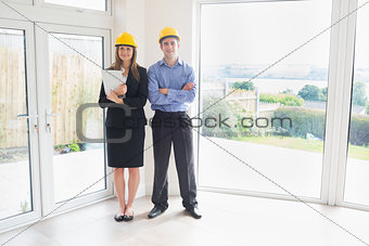 Estate agent and client wearing hardhats