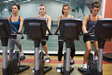 Four women working out at spinning class