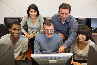 People standing and sitting at the computer
