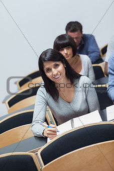 Smiling woman looking up from note taking