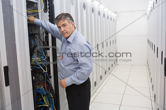 Man fixing wires of servers