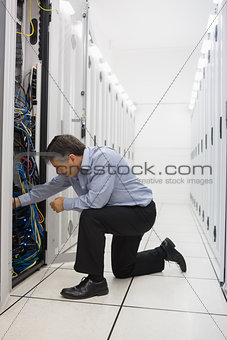 Man kneeling down and fixing wires