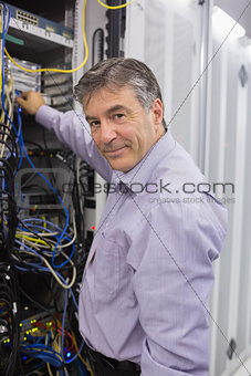 Man fixing wires while smiling